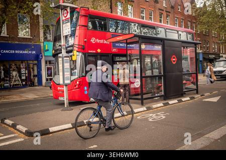 LONDRES - 15 AVRIL 2026 : CHISWICK HIGH ROAD W4 – bus rouge à l'arrêt de bus avec cycliste Banque D'Images