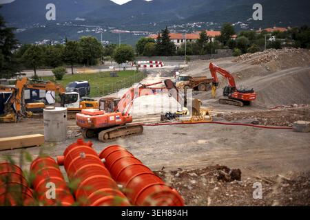 Zone de construction de routes à Kastav, Croatie, avec des pelles lourdes, des camions et de grands tuyaux de drainage orange. Banque D'Images