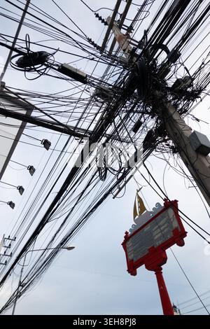 Gros plan de fils et de câbles électriques enchevêtrés sur un poteau de rue en Thaïlande Banque D'Images