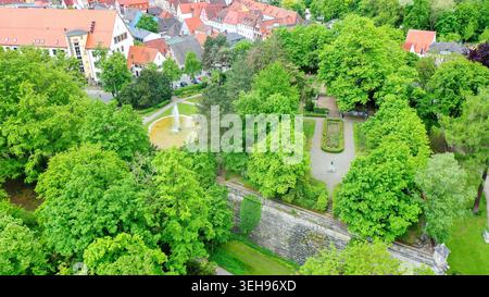 Vue aérienne du Stadtpark avec des arbres verdoyants, des bâtiments historiques au toit rouge et des fortifications en pierre à Forchheim, Bayern, Allemagne. Banque D'Images