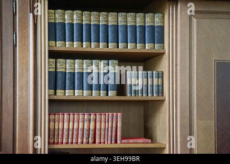 Volumes vintage du Grand Lexique de Révai exposés sur une étagère à l’intérieur du complexe gouvernemental du monastère des Carmélites de Budapest. Banque D'Images