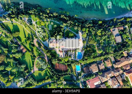 Vue aérienne de l'hôtel Villa Cortine Palace doté de piscines et de courts de tennis entourés de jardins luxuriants sur les rives du lac de Garde à Sirmione Banque D'Images