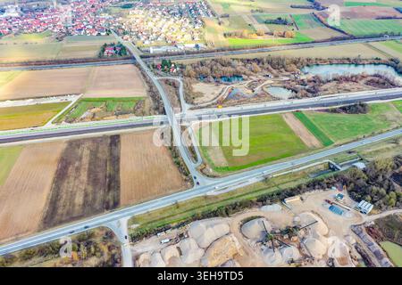 Vue aérienne de Buttenheim avec des maisons résidentielles, des champs agricoles et un carrefour routier majeur près d'un site industriel à Buttenheim, Bavière, Banque D'Images