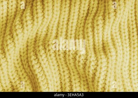Gros plan, macro de tricot jaune froissé avec des rides visibles, des plis et des vagues douces. Texture de laine douce avec des points et des plis détaillés, n Banque D'Images