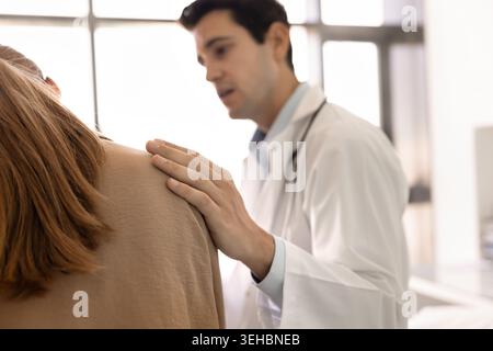 Gros plan médecin plaçant doucement la main sur l'épaule de la patiente Banque D'Images