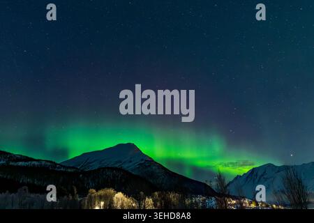 Aurores boréales (aurores boréales) éclairant le ciel nocturne au-dessus d'un paysage hivernal dans le nord de la Norvège. Banque D'Images