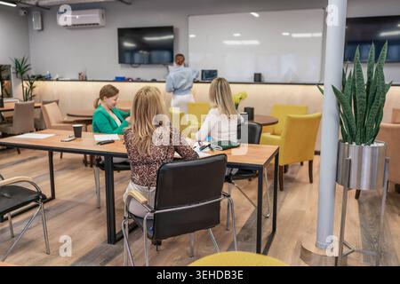 Réunion de présentation des femmes, les collègues assistent à un séminaire d'entreprise à longue table dans le bureau moderne Banque D'Images