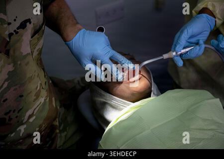 U.S. Air Force Reserve Lt. Col. John Chan, dentiste du 926e escadron de médecine aérospatiale, examine un patient pédiatrique au Pogson Medical Centre à San Banque D'Images
