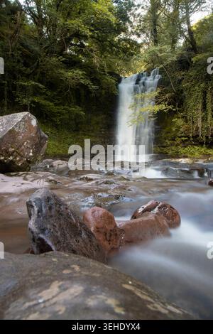 Chute d'eau en cascade sur des roches moussues créant une scène naturelle sereine Banque D'Images