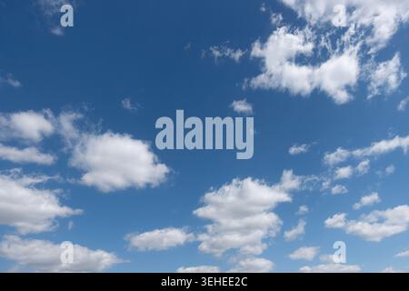 Ciel bleu large avec des nuages de cumulus blancs dispersés, un temps d'été propre et un espace de copie atmosphérique ouvert Banque D'Images