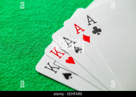 trois as et rois de type, mettre des cartes à jouer au poker sur un tissu vert Banque D'Images