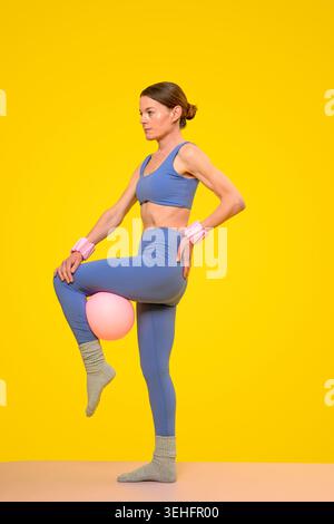 Femme en forme faisant des pilates avec une balle Banque D'Images