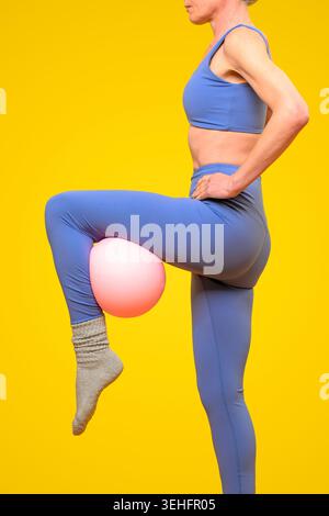Femme en forme faisant des pilates avec une balle Banque D'Images