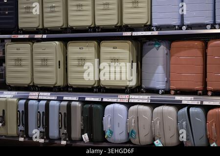 De nombreuses valises colorées et sacs de voyage se dressent sur les étagères d'un supermarché. Magasin de vente au détail de bagages, préparation touristique et équipement de passagers Banque D'Images
