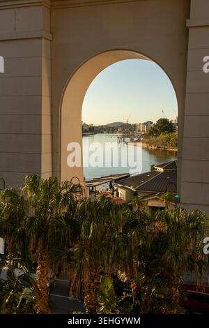Vue surélevée encadrée à travers un pylône en arc architectural en béton du Story Bridge donnant sur la Brisbane River au lever du soleil. 2025 Banque D'Images