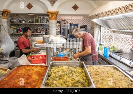 Les cuisiniers préparent des lasagnes dans une cuisine italienne animée Banque D'Images