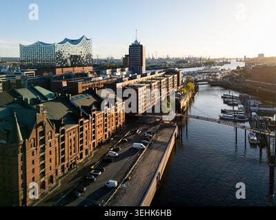 Vue aérienne du quartier historique des entrepôts de Speicherstadt et de la salle de concert moderne Elbphilharmonie le long de l'Elbe au coucher du soleil à Hambourg, Ha Banque D'Images