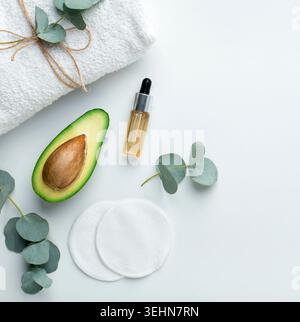 Huile d'avocat fraîche dans une petite bouteille sur fond blanc Banque D'Images