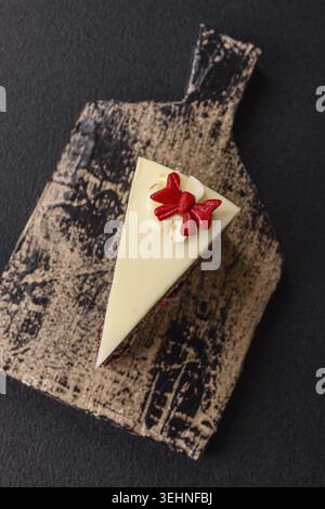Nourriture, morceau de cheesecake en couches sucré avec des cerises et des graines de pavot sur un fond texturé foncé Banque D'Images