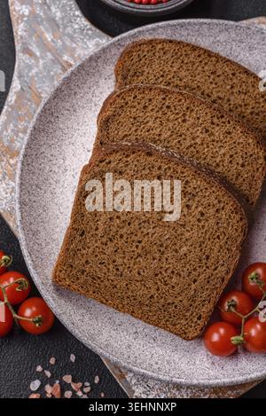 Nourriture, pain brun croustillant frais coupé en tranches de farine de grains entiers avec du sel et des épices Banque D'Images
