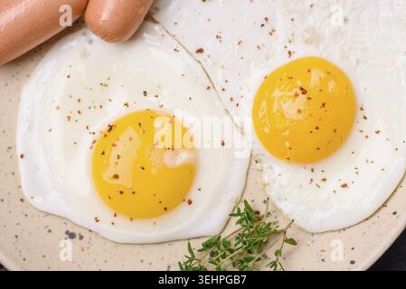 Nourriture, œufs de poule frits, saucisses, tomates cerises, pois chiches, épices, sel et herbes. Délicieux petit déjeuner nutritif Banque D'Images
