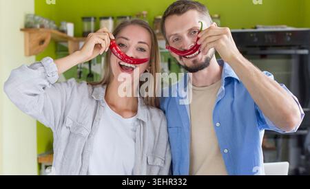 Jeune couple duper pendant la cuisson en cuisine vert Banque D'Images