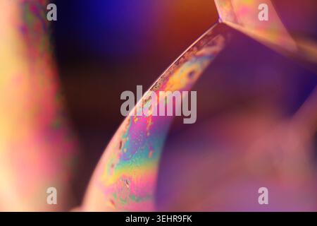 Plan macro abstrait d'avions liquides texturés avec éclairage orange et violet néon. Fond microscopique Banque D'Images