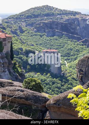monastères des météores perchés sur d'imposants piliers de roche entourés de vallées verdoyantes sous un ciel d'été lumineux en grèce Banque D'Images
