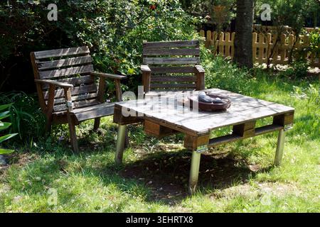 Chaises en bois rustiques maison et table dans un jardin en été Banque D'Images