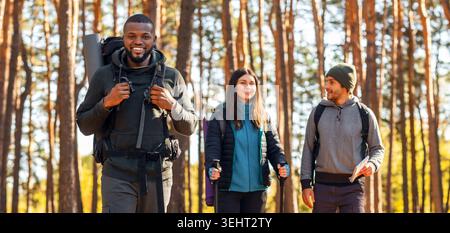 Heureux amis multiraciaux randonnée ensemble par la campagne Banque D'Images