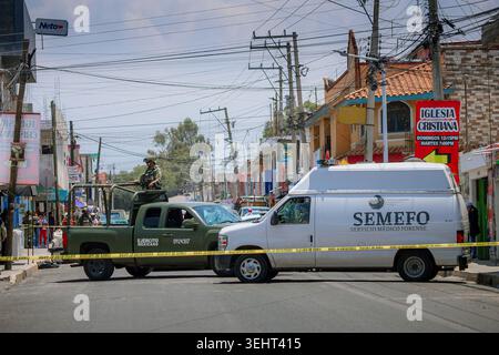 Une camionnette médico-légale et un camion de l'armée mexicaine gardent une rue bouclée pendant une opération d'application de la loi. Banque D'Images