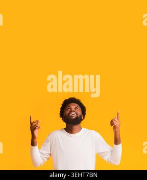 L'homme afro positive à la pointe vers le haut et à l'espace libre Banque D'Images