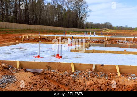Les travailleurs préparent le terrain pour le nouveau bâtiment de dalle de fondation avec des tuyaux d'ossature en bois dans la zone de construction Banque D'Images