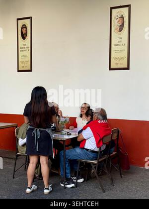 Les habitants déjeunent à l'intérieur du restaurant dans la cour du cloître de la Parroquia de San Juan Bautista à Coyoacán, Mexico, Mexique Banque D'Images