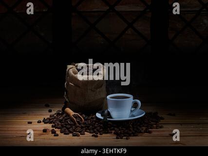 Moody Still Life de café chaud fraîchement préparé dans une tasse en céramique blanche avec vapeur visible. Banque D'Images