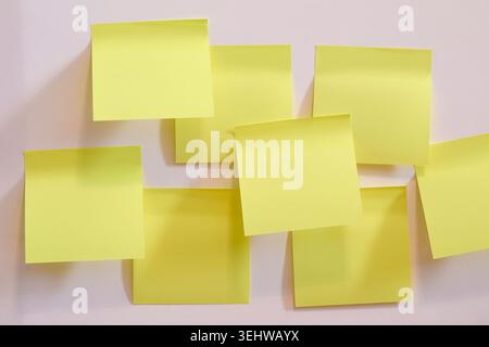 Poster des notes jaunes vierges sur le mur Banque D'Images