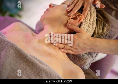 Femme obtenant le massage corporel relaxant dans la clinique médicale sous les soins d'un thérapeute masseuse professionnel. Banque D'Images