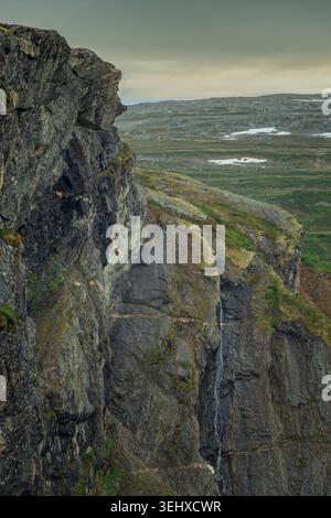 Aurstaupet, Norvège - 22.06.2024 : vue verticale spectaculaire des falaises rocheuses escarpées et escarpées d'Aurstaupet, Norvège, où une fine cascade descend en cascade Banque D'Images