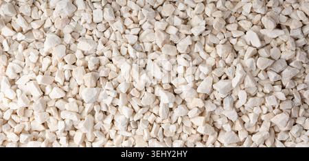 Fond texturé de galets de quartzite écrasé, pierres de marbre décoratives blanches en gros plan. Petit motif de gravier, calcaire blanc naturel pour la décoration de jardin Banque D'Images