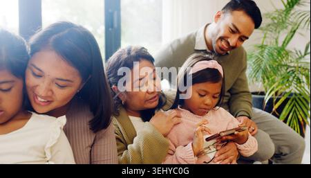 Famille heureuse, jeux sur smartphone et filles sur canapé, Internet et liaison avec de l'aide. Maison, grand-parent et mère avec père, enfants et Banque D'Images