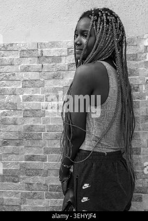 Portrait d'une jeune femme noire avec de longs cheveux tressés contre le mur. IZMIR, TURQUIE - 21 juillet 2019 Banque D'Images
