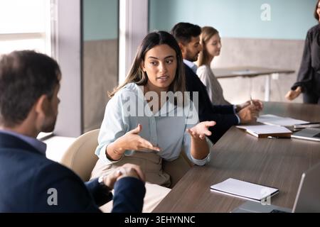 Femme expliquant la stratégie d'entreprise, partageant l'idée pendant le travail d'équipe avec un collègue Banque D'Images
