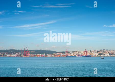 LISBONNE, PORTUGAL - nov 09, 2025 : cargo commercial est amarré à un port terminal à conteneurs à Lisbonne, Portugal, vu à travers le Tage Riv bleu Banque D'Images