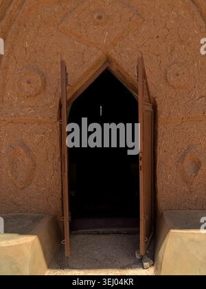 Zaria, Nigeria - 22 mars 2026 : vue de l'architecture traditionnelle de boue de Wusasa avec une porte ouverte et des motifs géométriques de murs. Banque D'Images