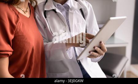 Gros plan d'un médecin spécialiste utilisant des comprimés consultant une patiente Banque D'Images