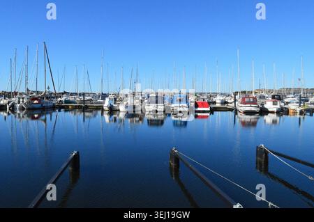 Yachts et bateaux à moteur amarrés dans un port de plaisance - Ystad, Suède. De nombreux yachts à voile et bateaux à moteur sont amarrés le long d'un quai dans une marina Banque D'Images