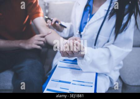Travailleur de la santé fournissant un soutien empathique et des soins, en plaçant doucement les mains sur le bras d'une femme âgée Banque D'Images