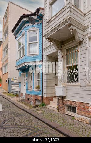 Charmantes maisons traditionnelles ottomanes en bois bleu et blanc bordent une rue pavée dans le quartier de Kuzguncuk, Istanbul, Turquie. Architecture historique Banque D'Images