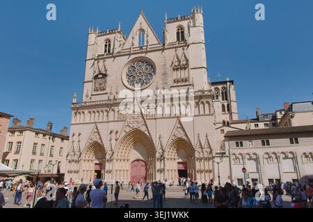 Vue horizontale grand angle de la place Saint Jean animée et de la cathédrale historique entourée de bâtiments traditionnels dans le Vieux Lyon, France. Banque D'Images