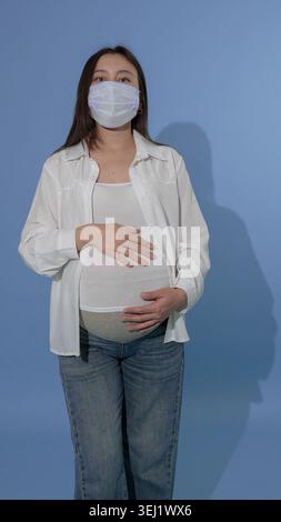 Femme enceinte portant un masque médical protecteur Banque D'Images